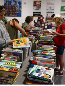 People looking at a table of sale books